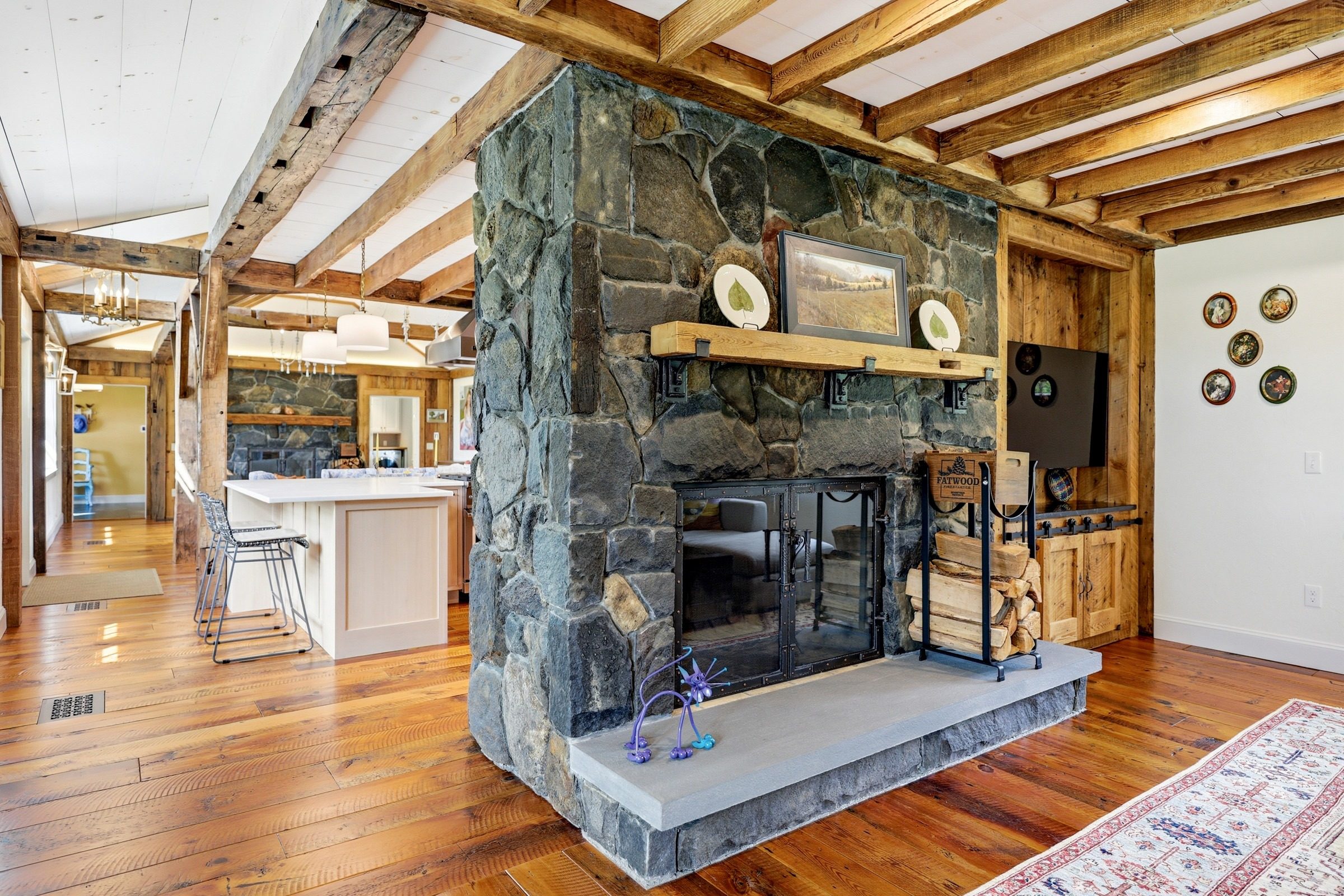 Fieldstone fireplace beneath exposed hand-hewn beams