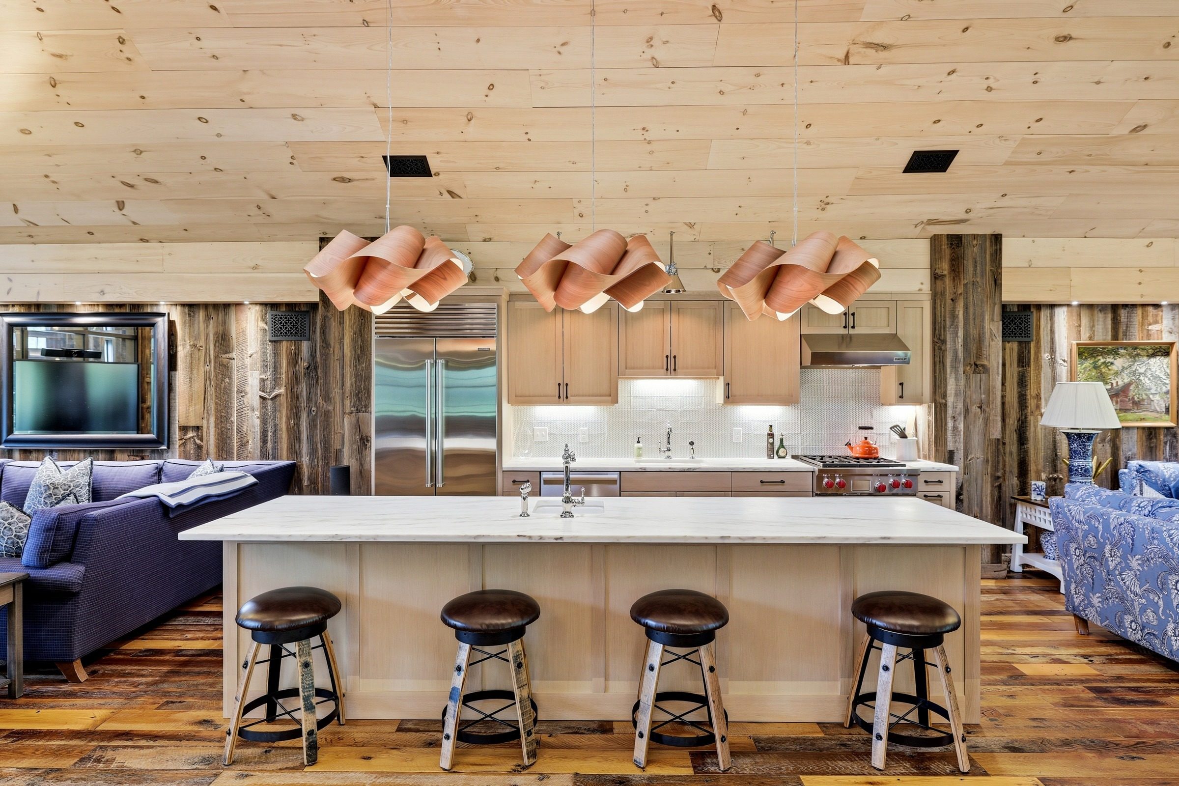 The barn kitchen, with a long island and copper pendants